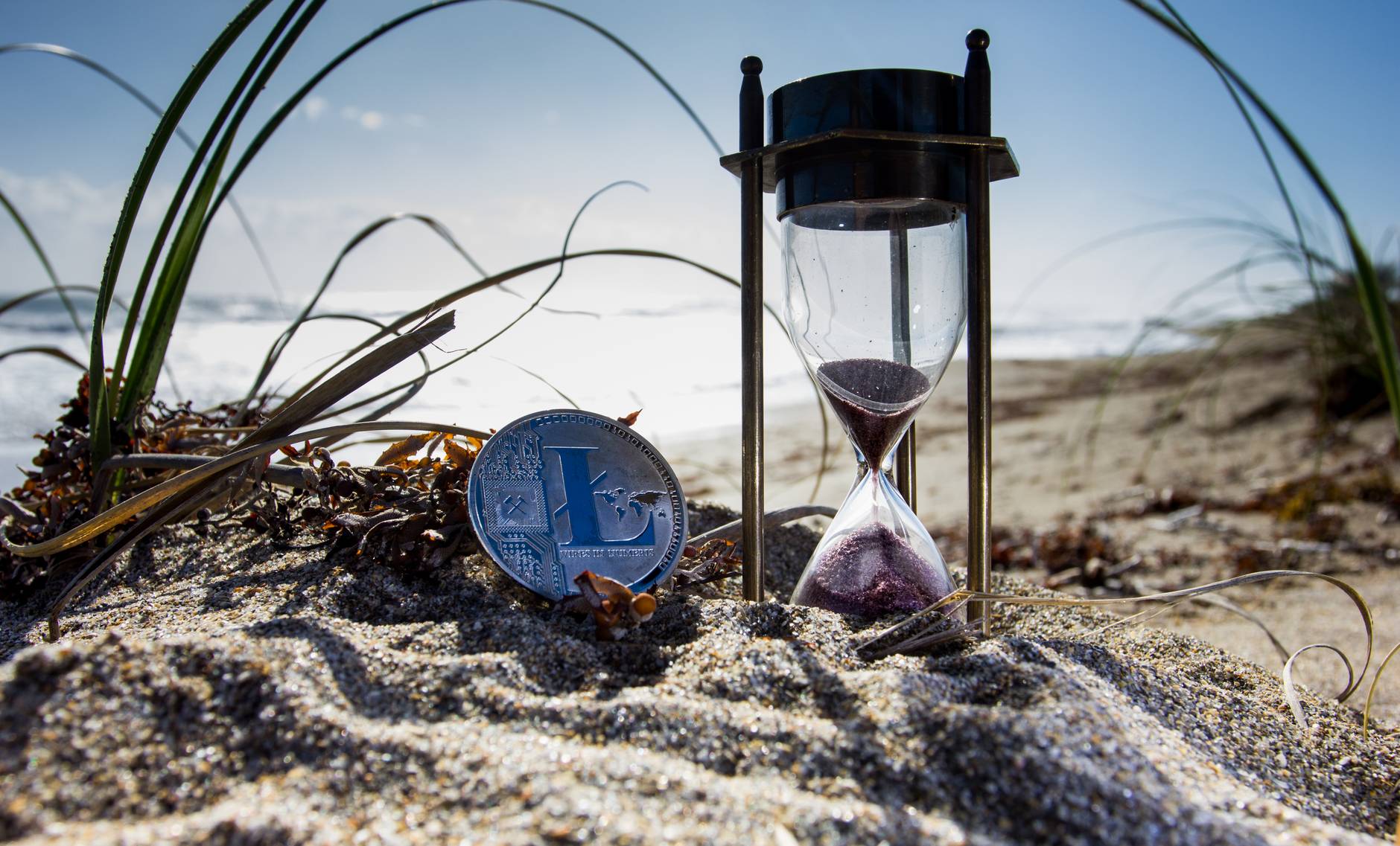 clear hour glass on brown sand