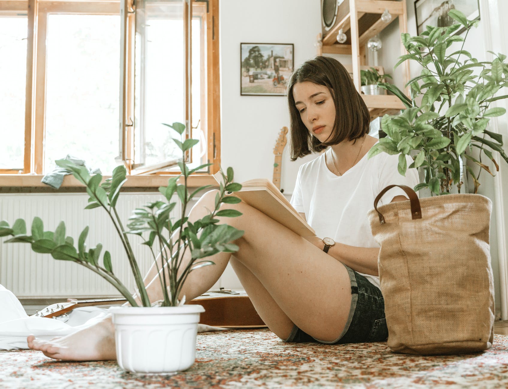 young woman reading book in cozy room