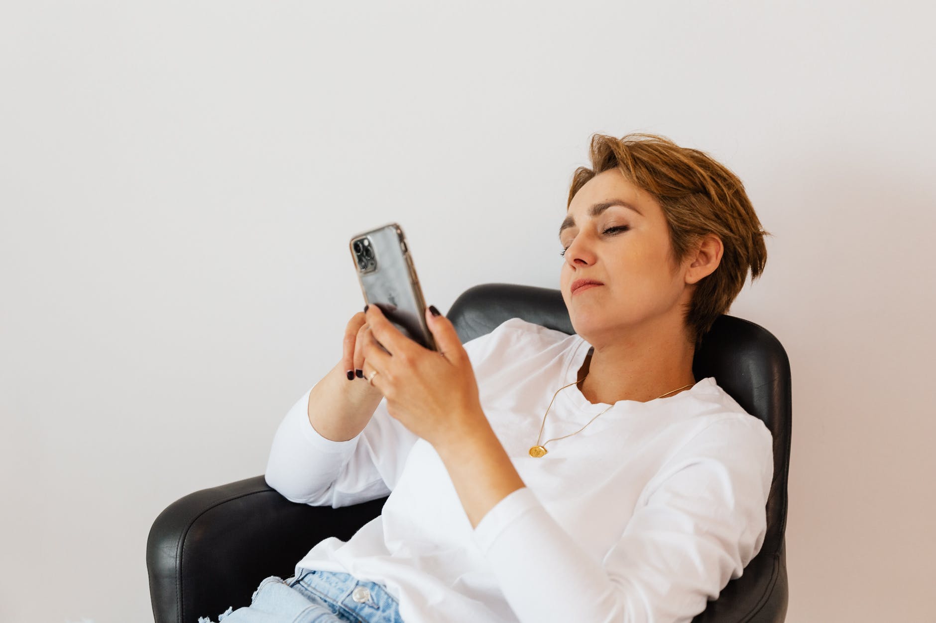 calm woman surfing internet on smartphone while sitting on chair