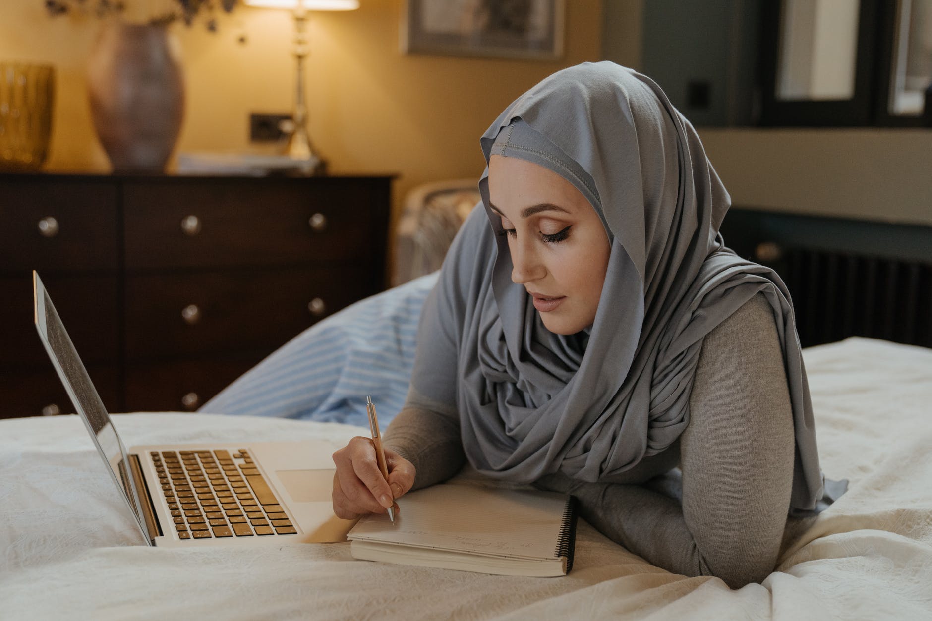 woman in gray hijab using macbook air